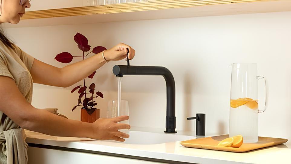 Woman taking water from a running tap
