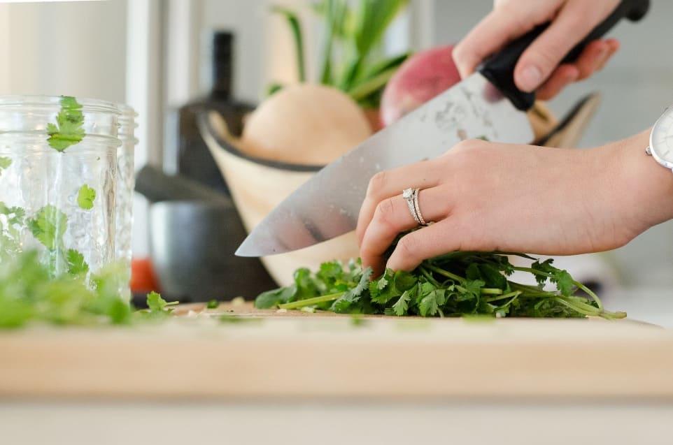 person cutting vegetables with a knife